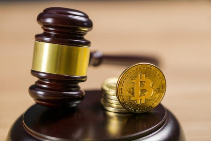 Réglementation Bitcoin. Pièce cryptographique BTC et marteau sur un bureau. Photo de la réglementation Bitcoin. Pièce cryptographique BTC et marteau sur un bureau.